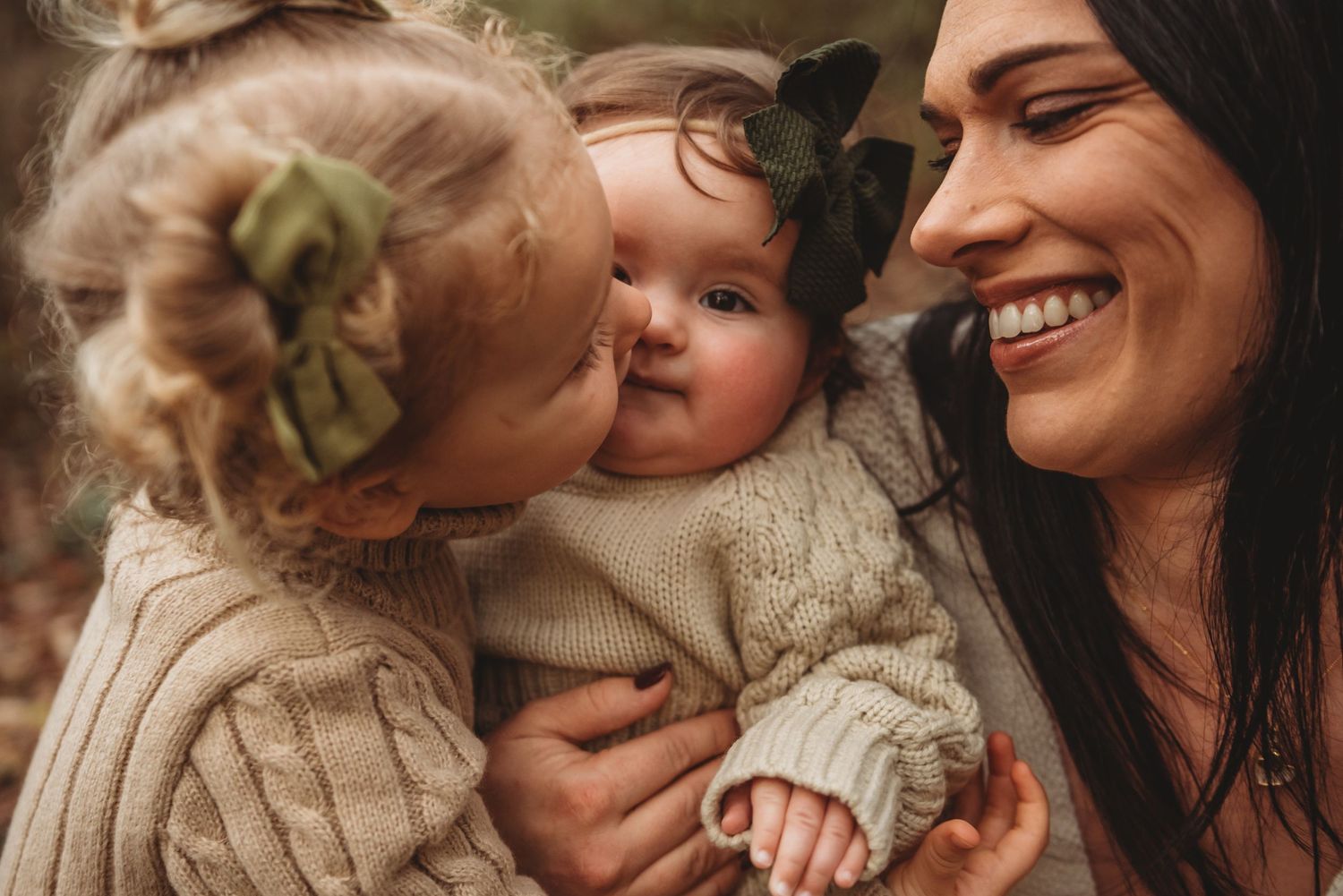 A loving moment shared between people wearing beige knit sweaters in warm natural lighting.