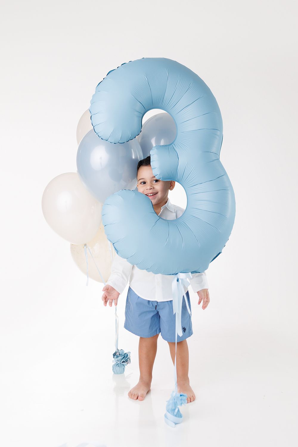 Child wearing light blue inflatable donut costume shown from different playful angles against white background.