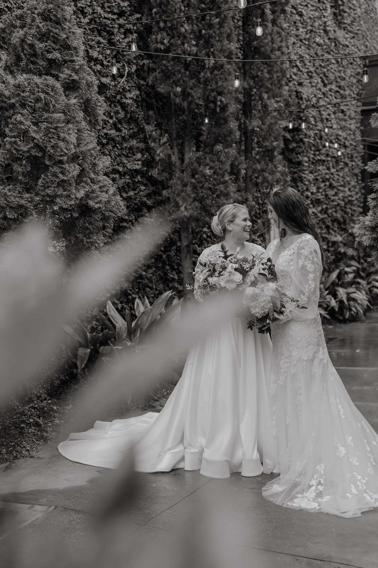 Black and white wedding portraits showing two brides in elegant white gowns.