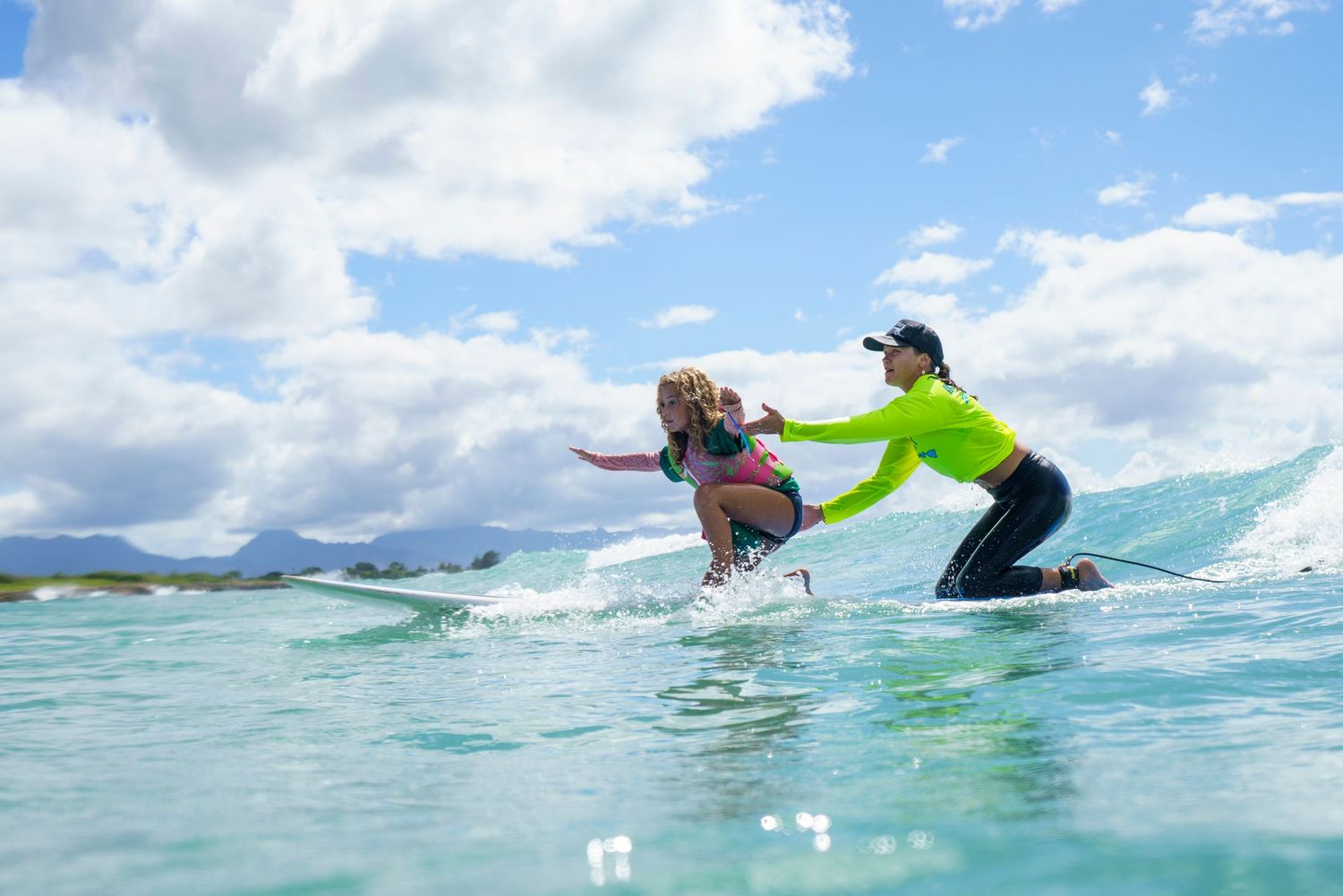 Surfers catching waves and enjoying the ocean on a beautiful day in Hawaii.