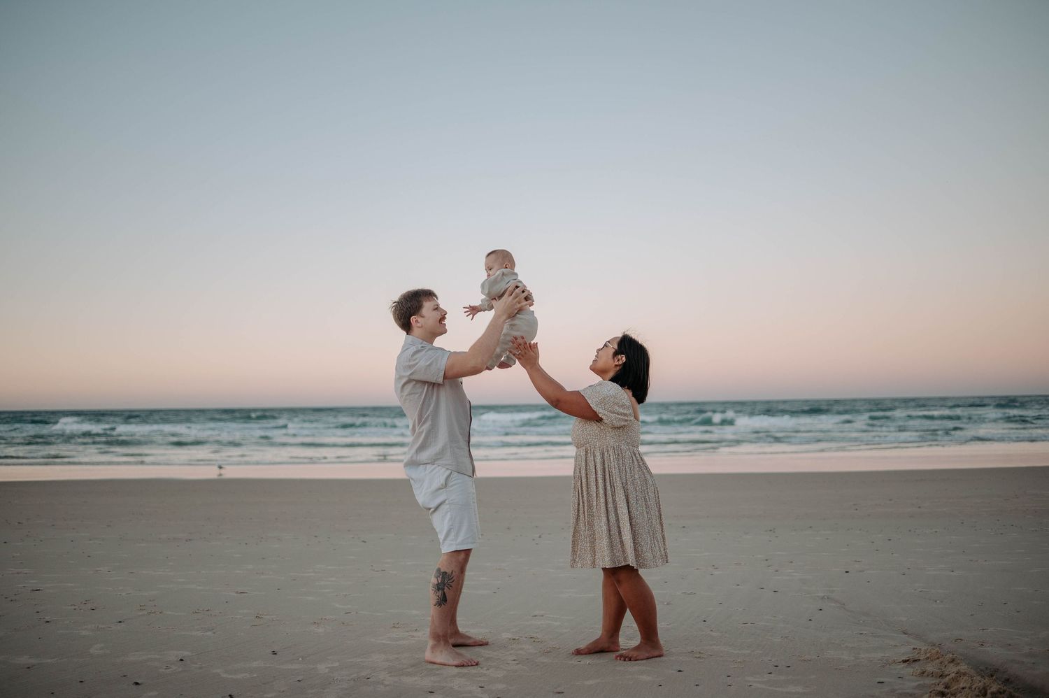 A group poses for a sunset family portrait by the water.