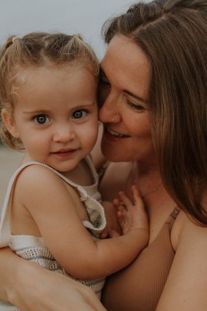 A tender moment between parent and child in a warm-toned photo collage showing loving interaction and cuddles.