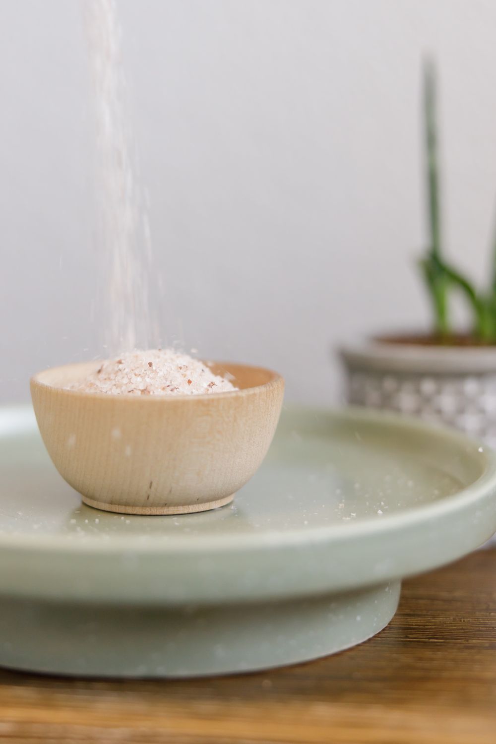 branded stock photo of pink Himalayan salt being poured into a wood bowl in Tacoma, WA for chiropractic business