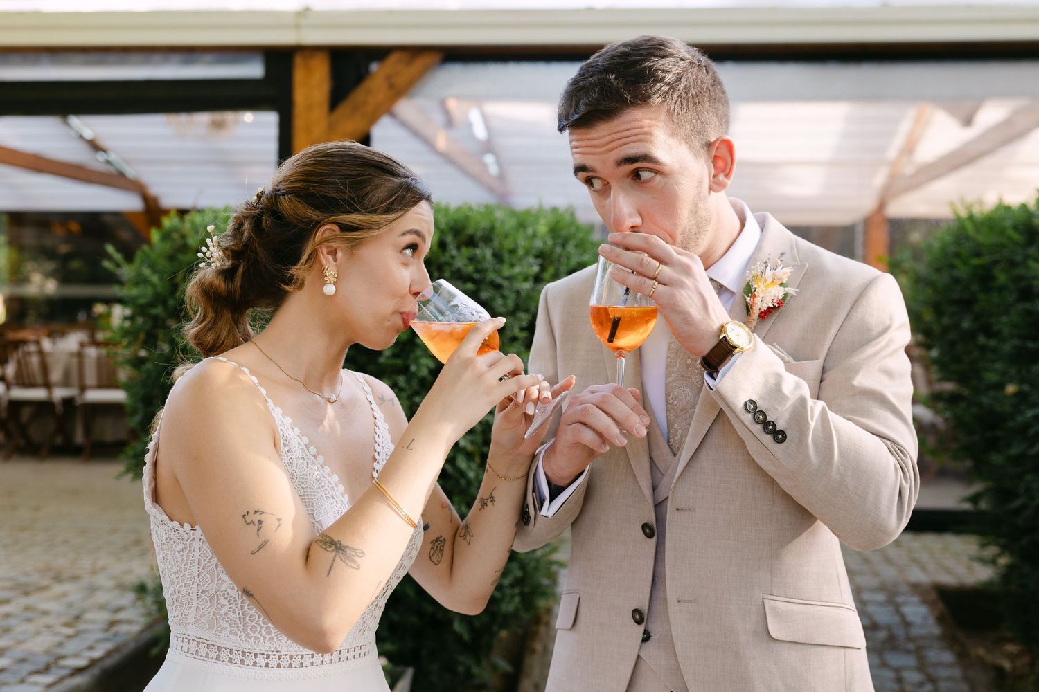 Bride and groom sipping Aperol Spritz cocktails together outdoors at their wedding reception at Quinta do Louredo, Évora, Alentejo