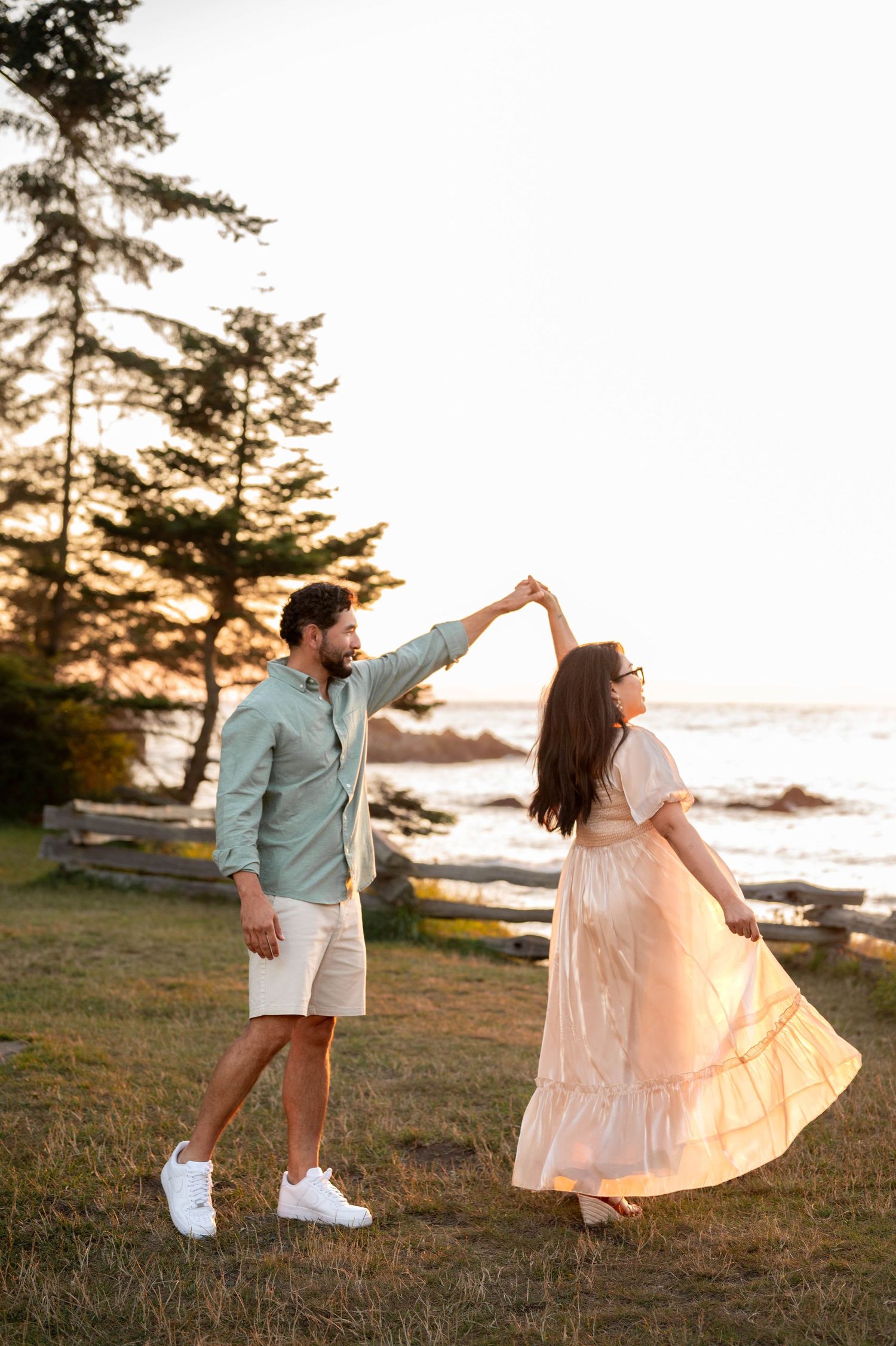 A couple shares a romantic dance pose at sunset at Deception Pass State Park in Washington State.