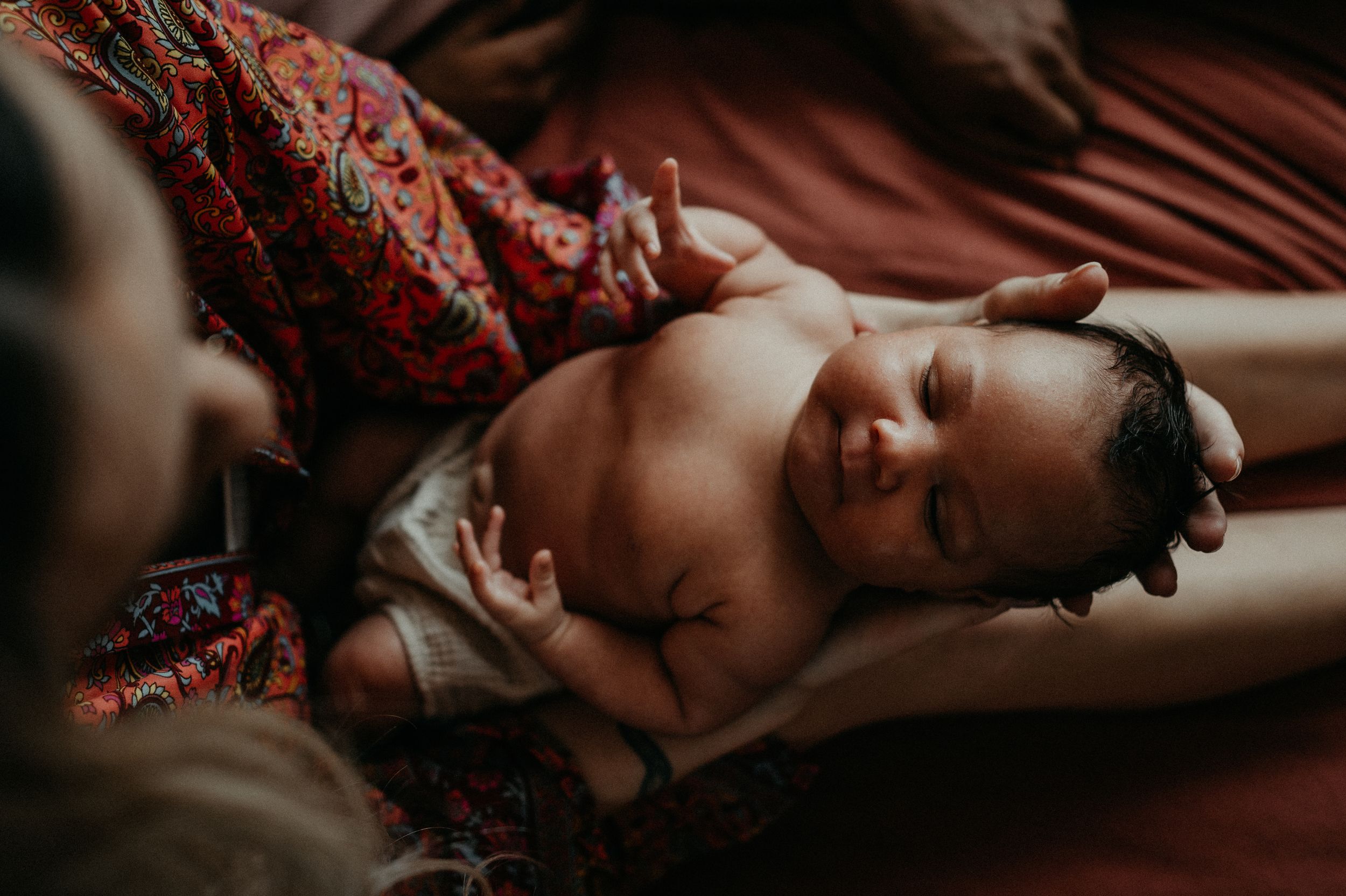 An image of a new born in her mother's arms during an in home new born session in London