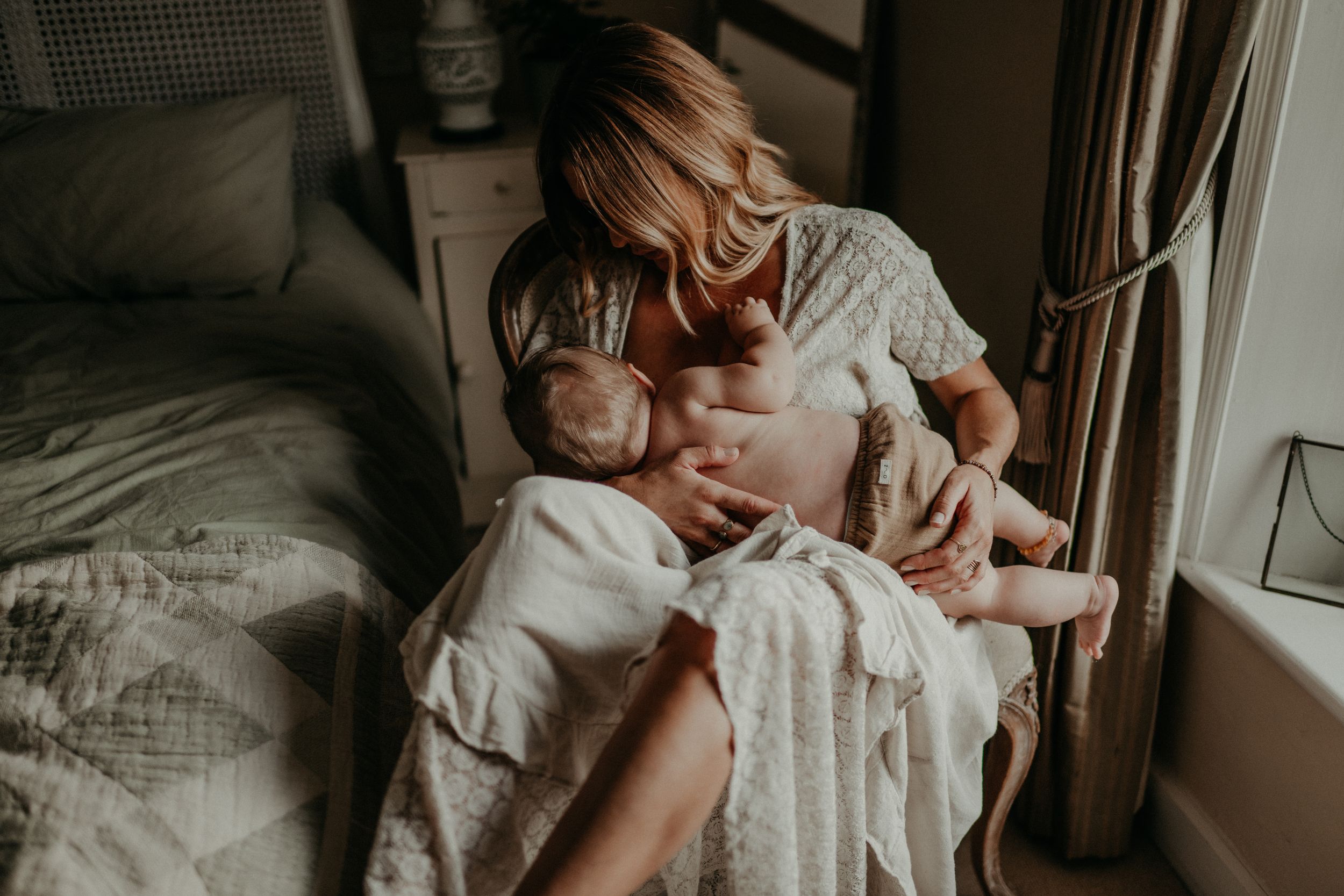A mother nursing her baby during a motherhood photo session in Kent