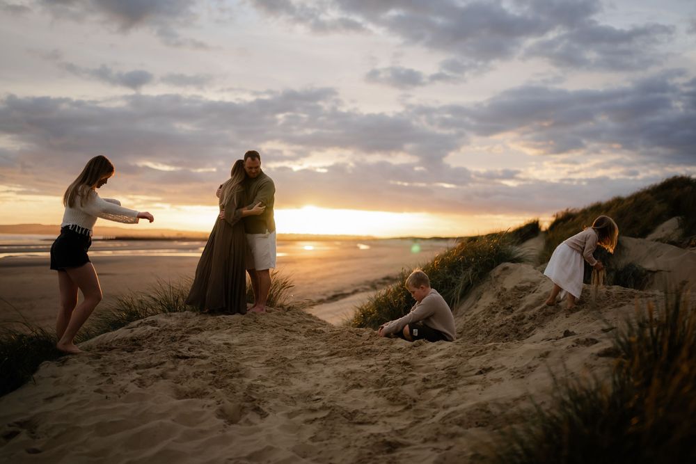 A family of five spending time on the beach at sunset during their photo session in kent