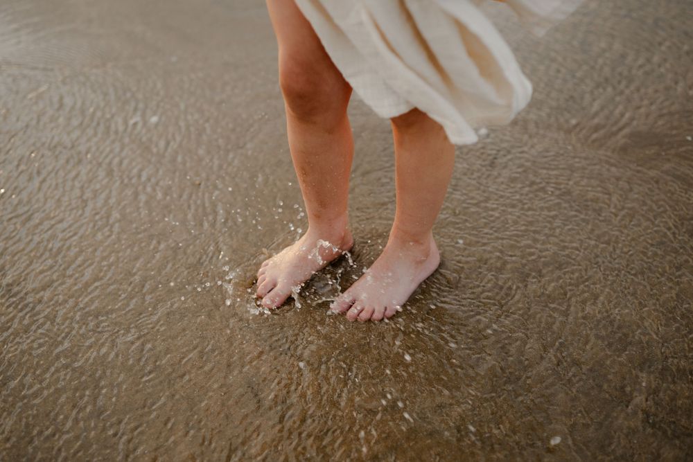 a close up of a girl's feet splashing in the water, kent family photographer