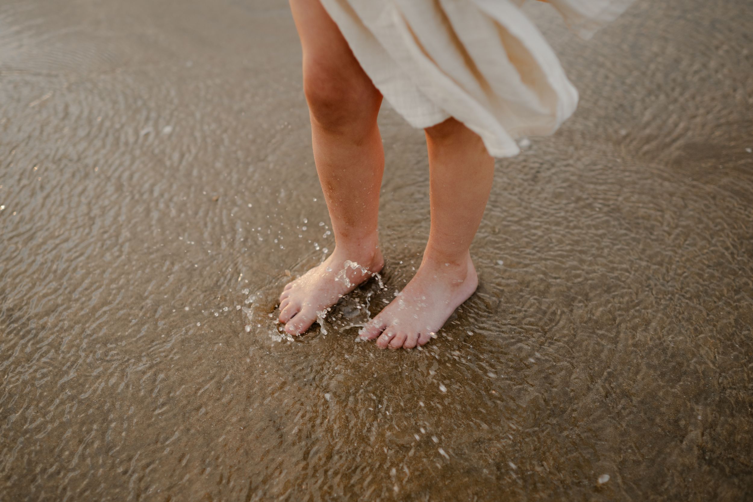 a close up of a girl's feet splashing in the water, kent family photographer