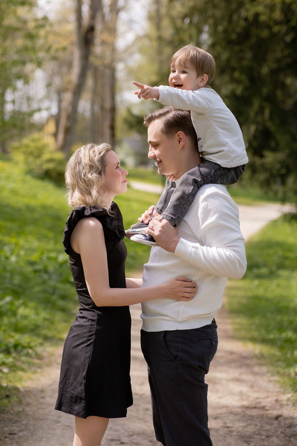 A playful moment captured between two people in a park setting wearing contrasting black and white outfits.