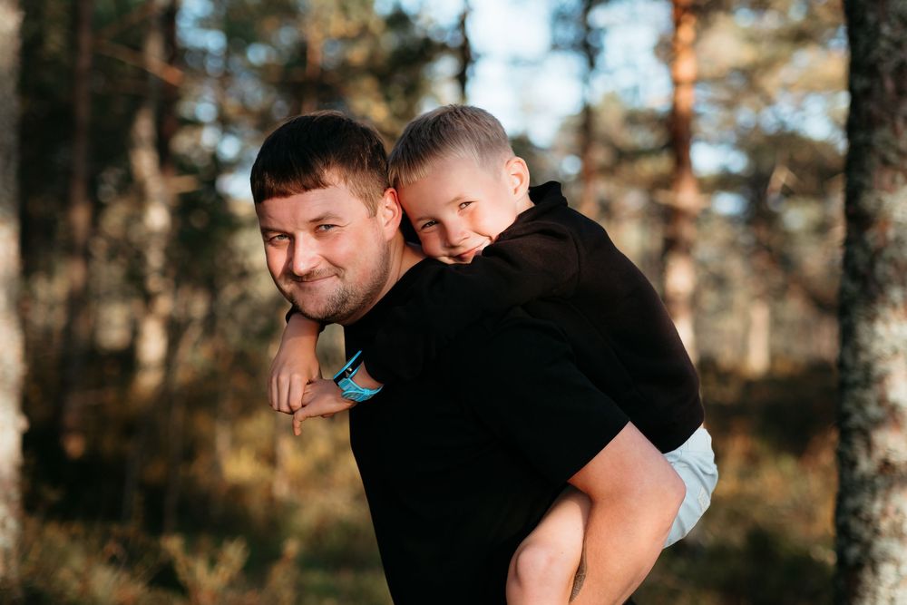 A parent and child share a tender moment outdoors during golden hour lighting.