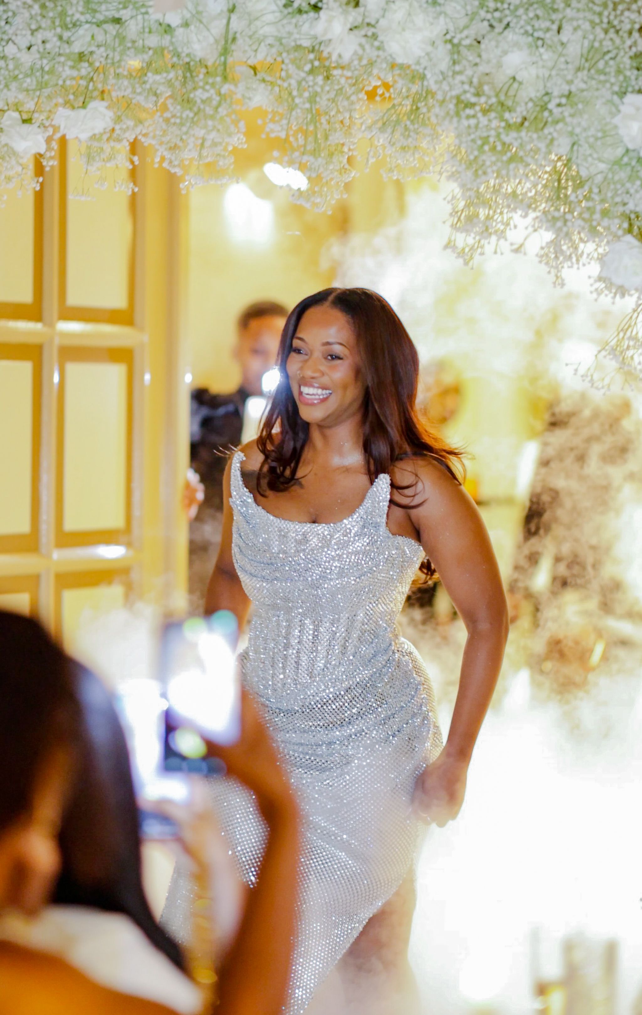 A sequence of candid moments at an elegant event with sparkling decor and floral arrangements overhead.