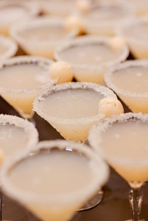 Close up of margarita cocktails with salt-rimmed glasses arranged in rows.