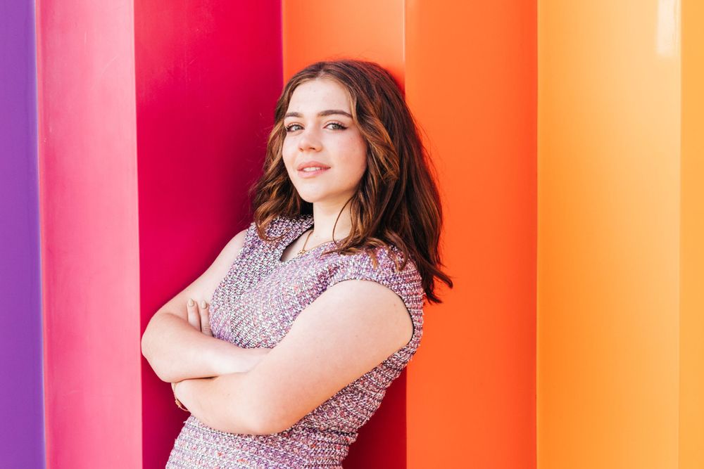 Portrait series against vibrant rainbow-colored striped wall background.