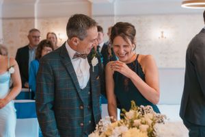 Wedding reception candid moments with guests laughing at decorated indoor venue.
