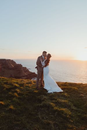 Romantic sunset moment captured on scenic coastal cliffs overlooking the ocean.