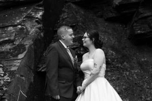 Black and white wedding portraits captured against dramatic rocky backdrop.