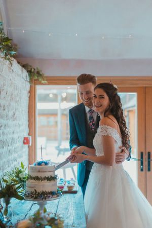 Newlyweds sharing a joyful moment during their wedding cake cutting ceremony.
