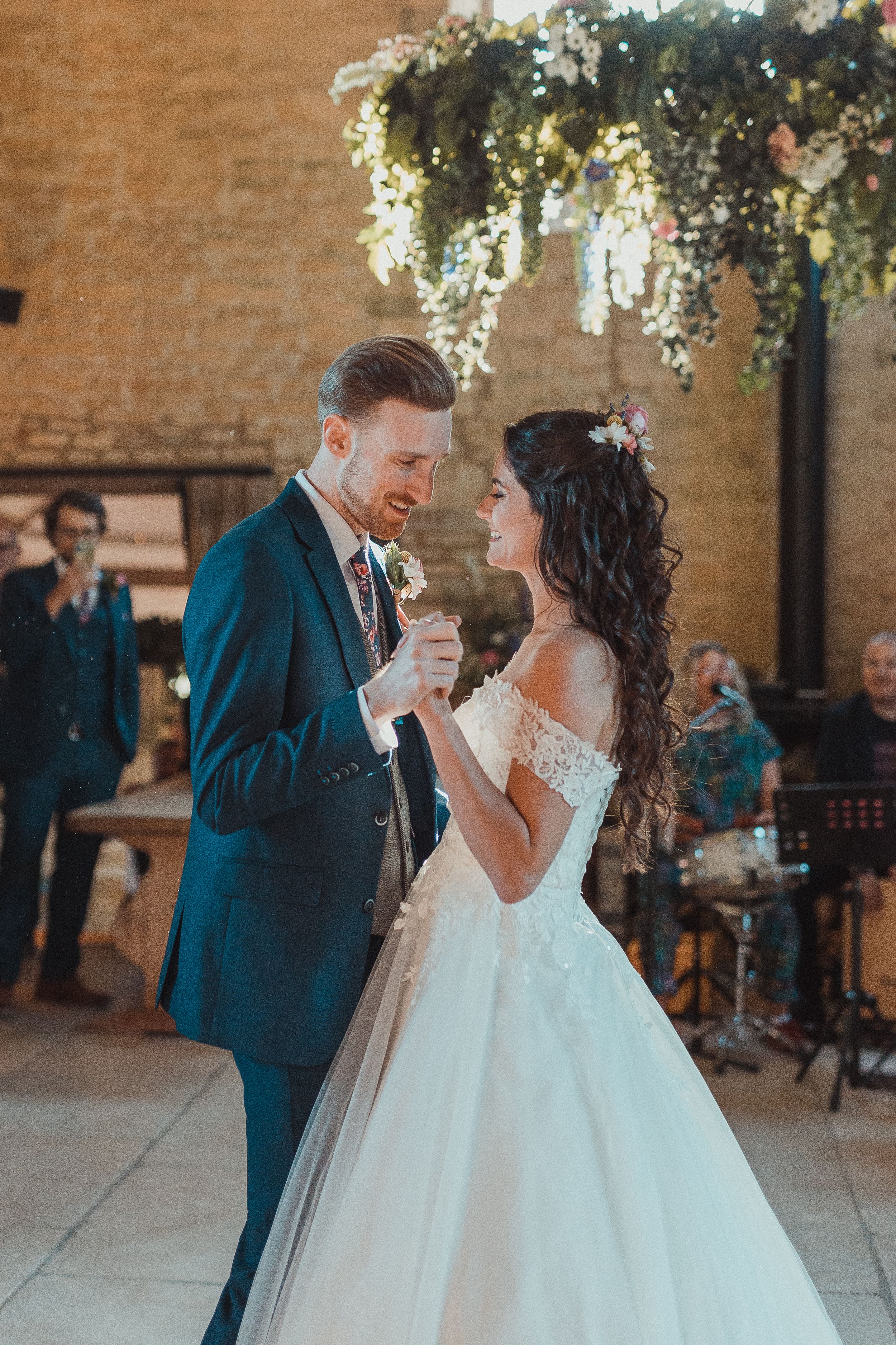 Elegant couple sharing their first dance in a beautifully decorated rustic venue.