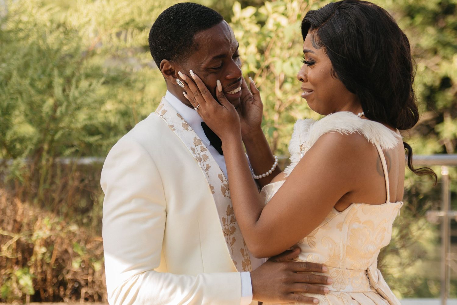 A romantic wedding portrait of a couple sharing a tender moment in a garden setting.