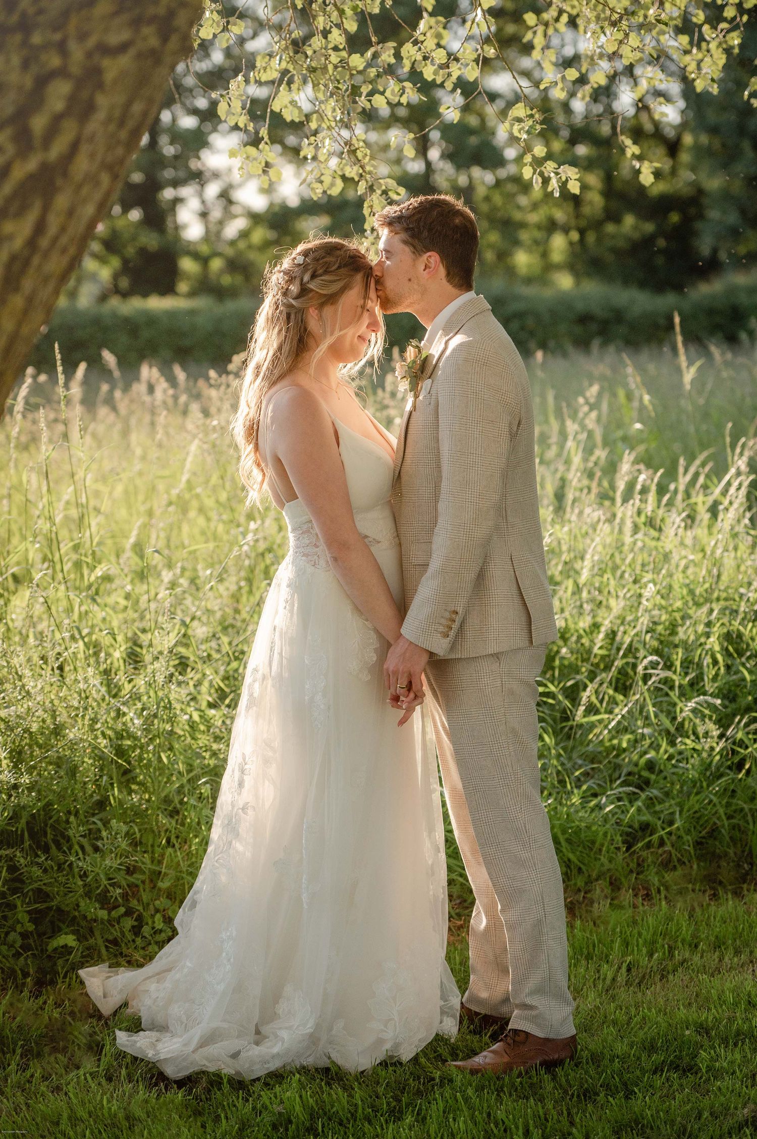 Golden hour image of couple having a special moment under a tree in the sunset light.