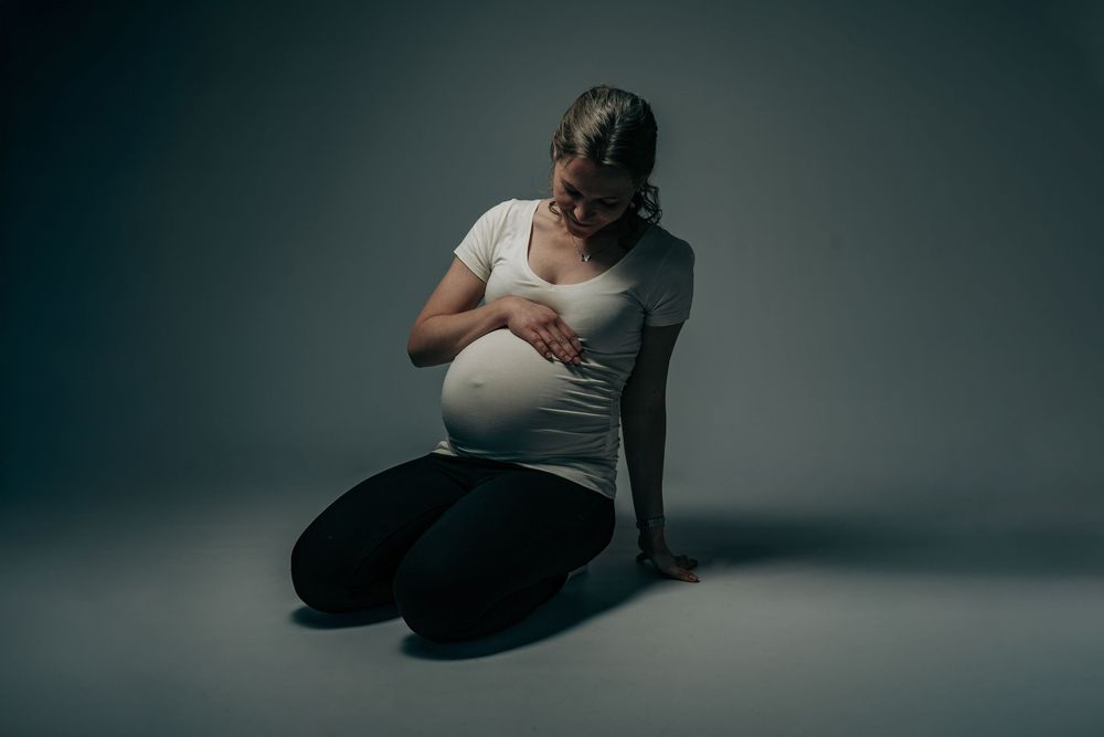 Kunstnerisk graviditetsportræt i studie med fokus på mave og roligt lys – fotograferet i Nordsjælland af CHH_foto