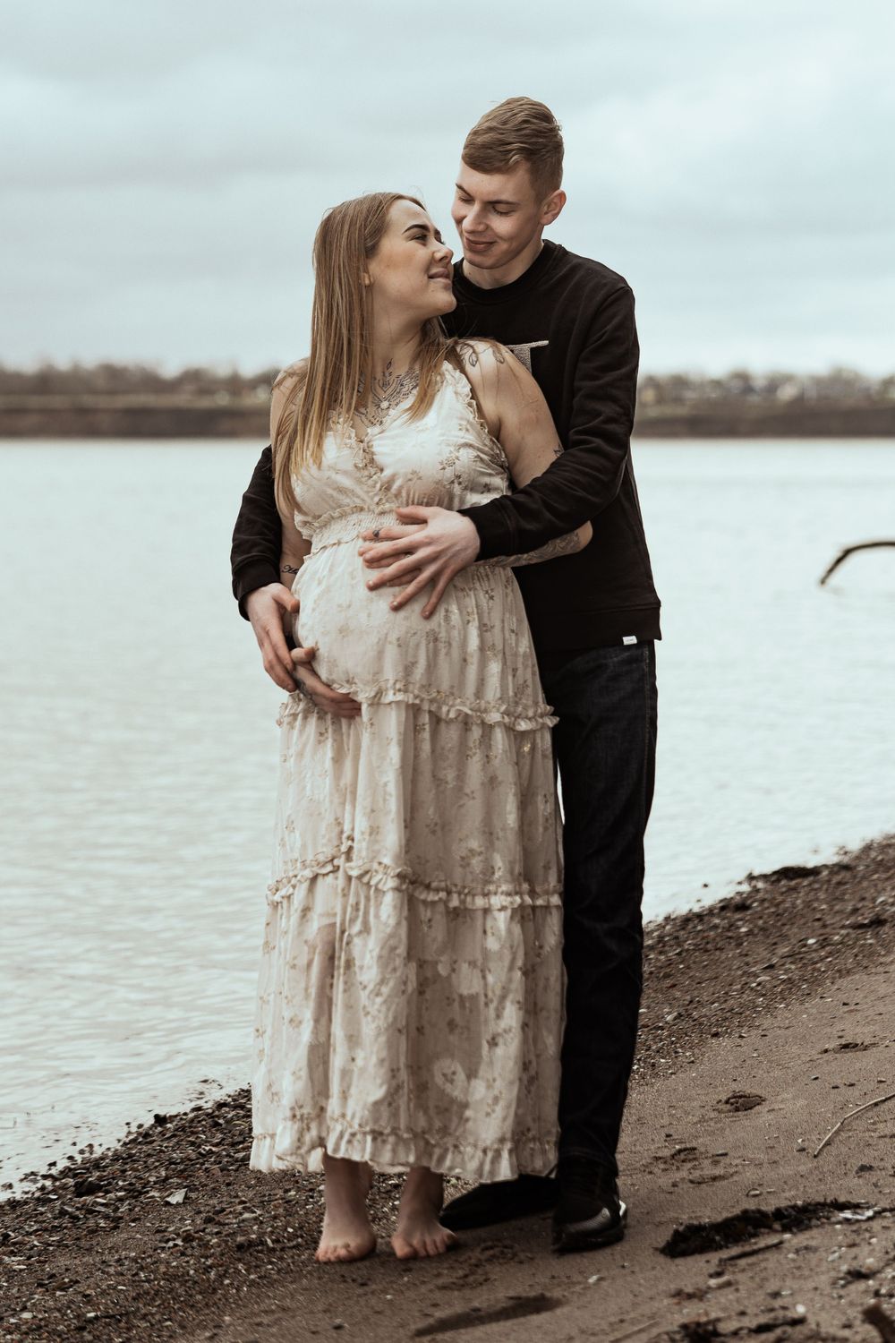 Udendørs gravidfotografering ved vandet – par portræt af kommende forældre. Professionel gravidfotograf i Jægerspris, Frederikssund