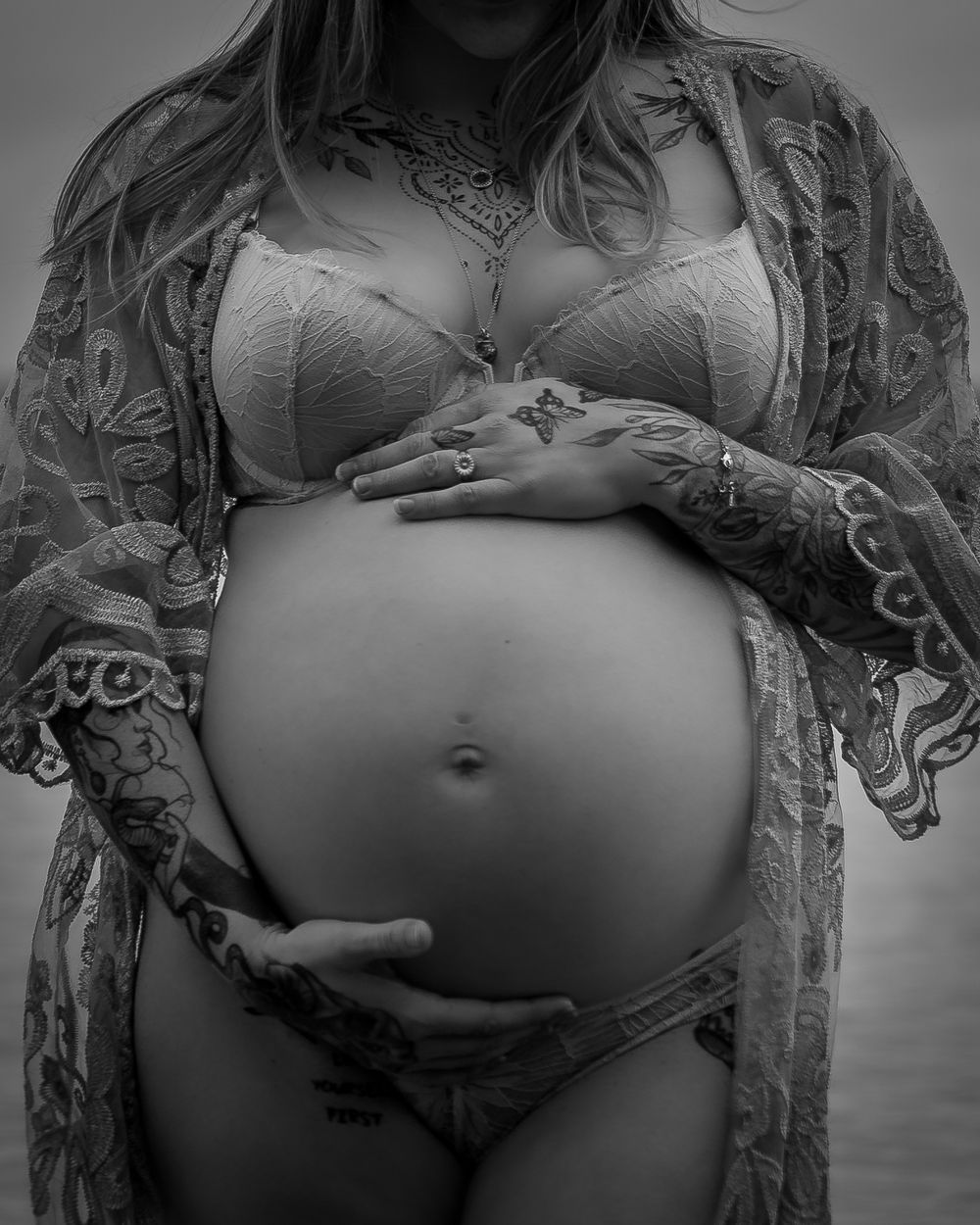 Gravidfoto ved vandet i smuk, intim stil. Fokus på mave og detaljer. Professionel gravidfotograf i Jægerspris, Frederikssund og Nordsjælland