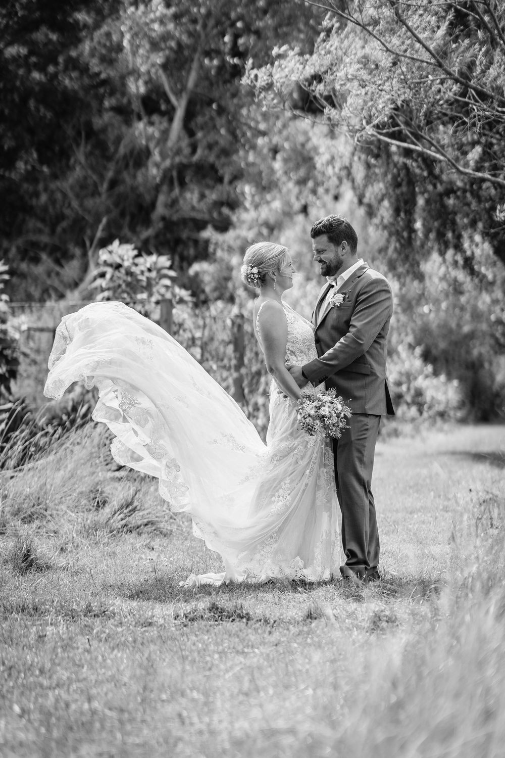 Romantisk bryllupsportræt i naturen med brudepar og flyvende slør – fotograferet af bryllupsfotograf i Jægerspris, Frederikssund