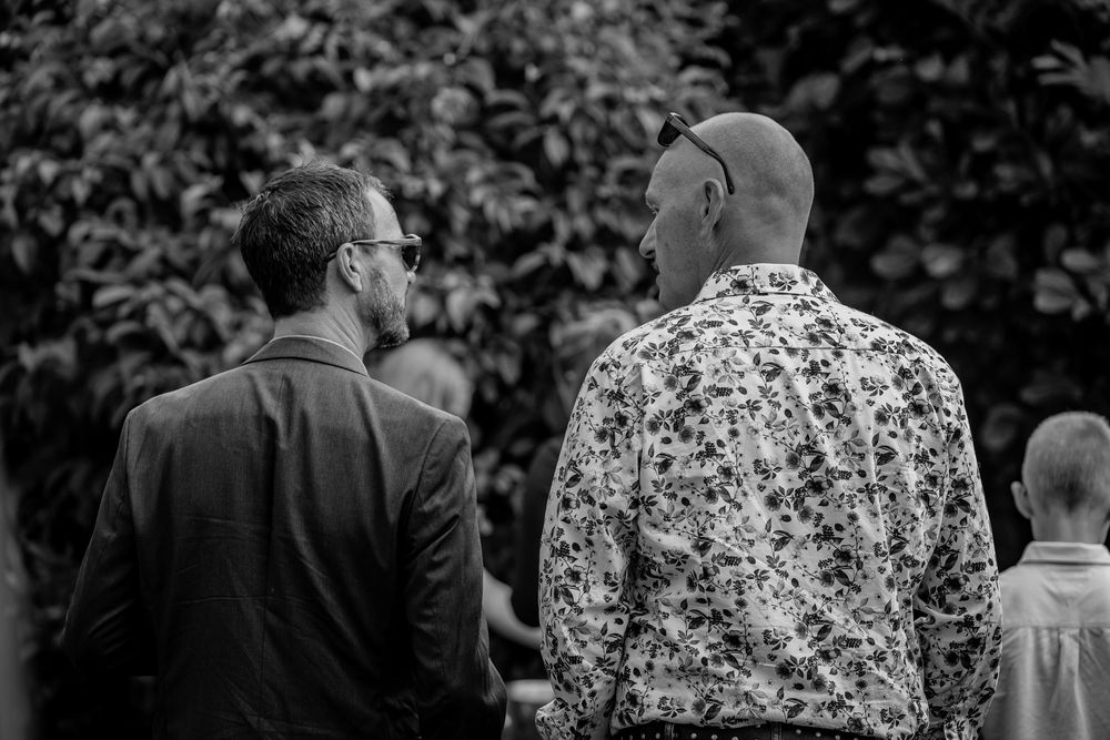 “Gæster i samtale til udendørs bryllup – stemningsfuldt øjeblik fotograferet i Jægerspris, Frederikssund og resten af Nordsjælland