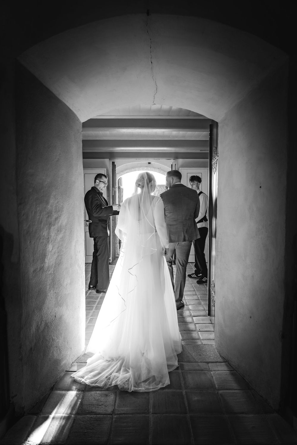 Bryllupsfoto af brud på vej ind i kirken – stemningsfuld sort/hvid portrættering af bryllupsdag, taget af fotograf i Jægerspris,