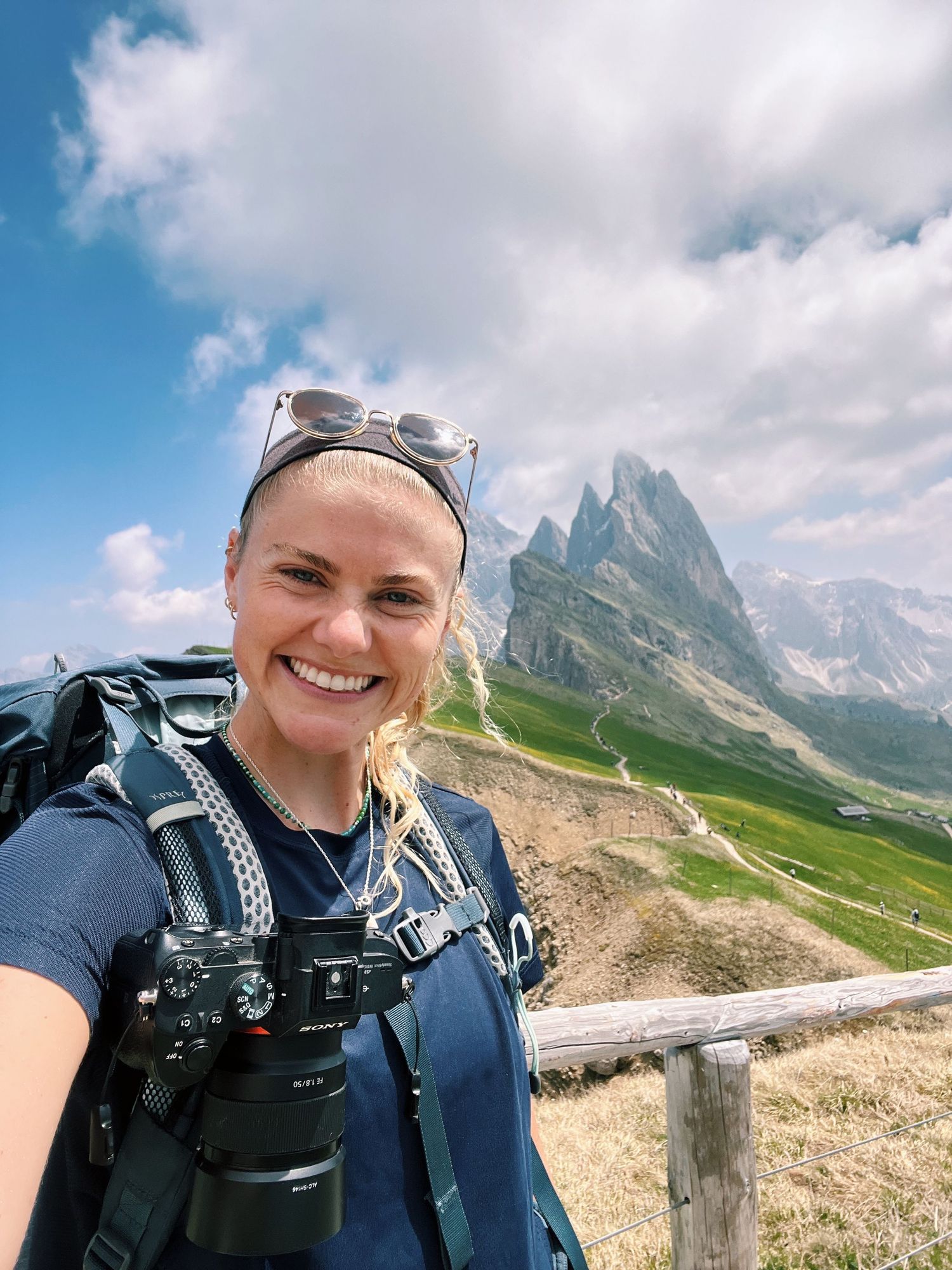 A hiker poses in front of dramatic mountain peaks in the Dolomites.