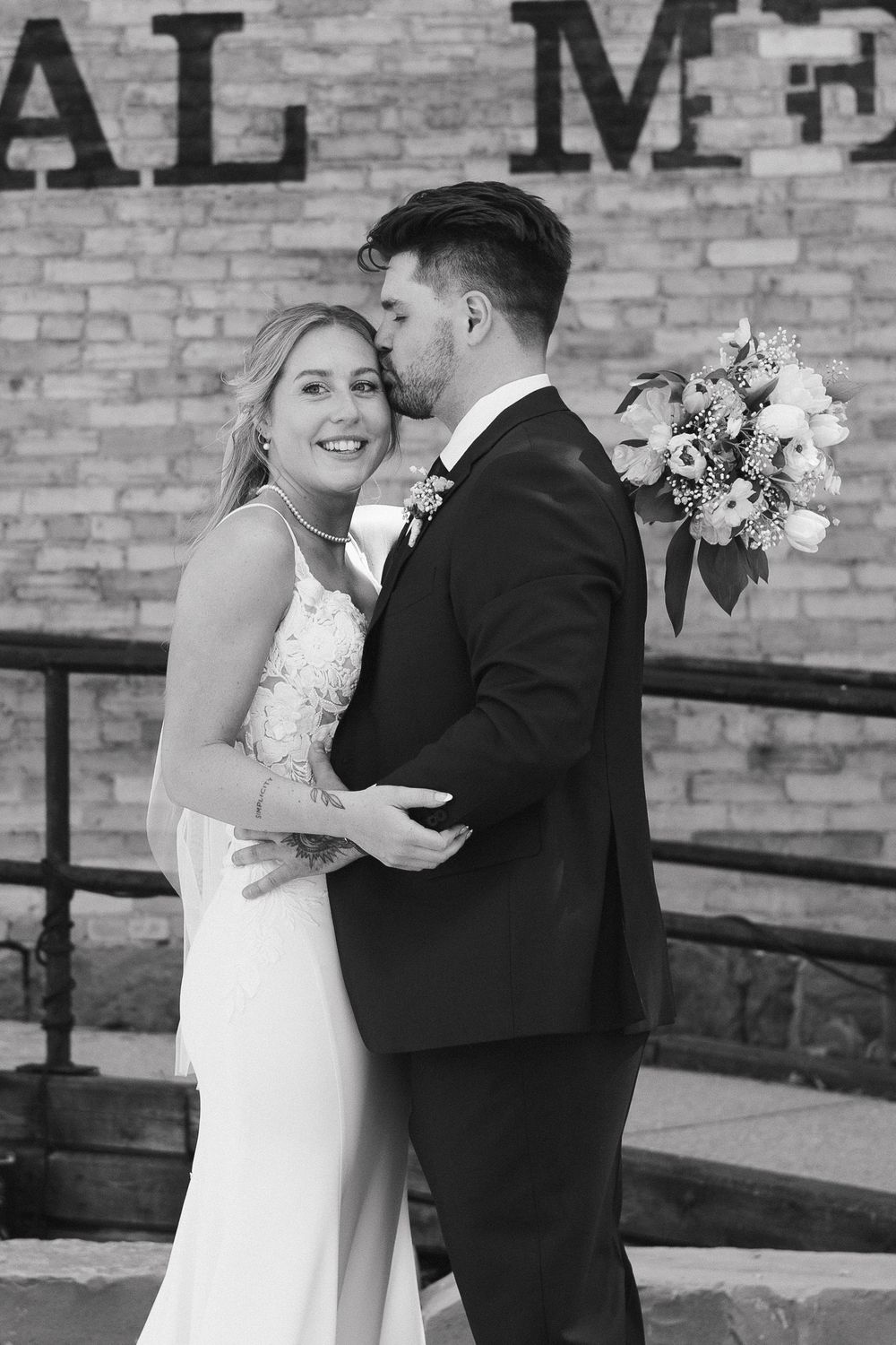 A romantic black and white wedding photo sequence showing a couple embracing against a brick wall backdrop.