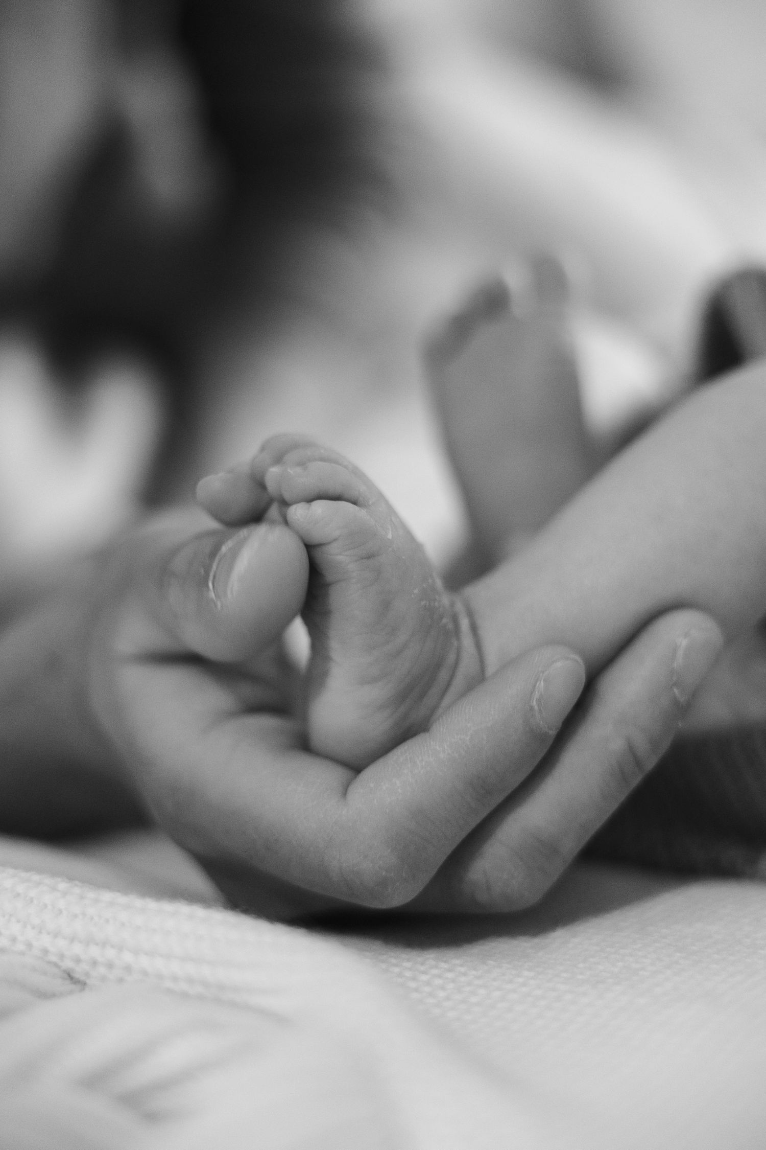 Parents admiring their newborn baby in a cozy room with warm lighting.