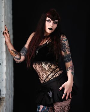 David G Holt Photography - Gothic model with tattoos poses in black lace against dark background.