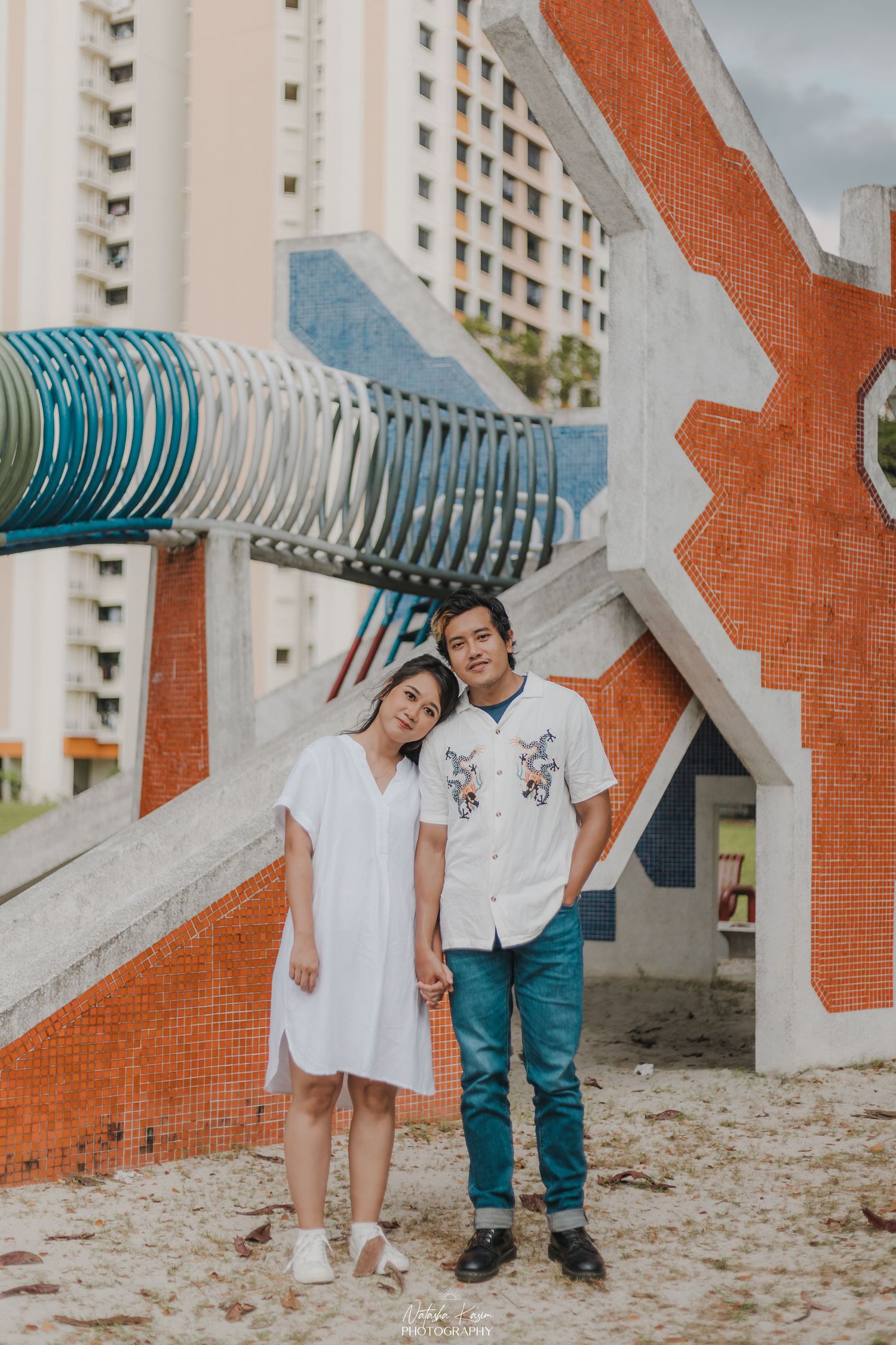 Romantic photoshoot against pink and turquoise Peranakan shophouse architecture.