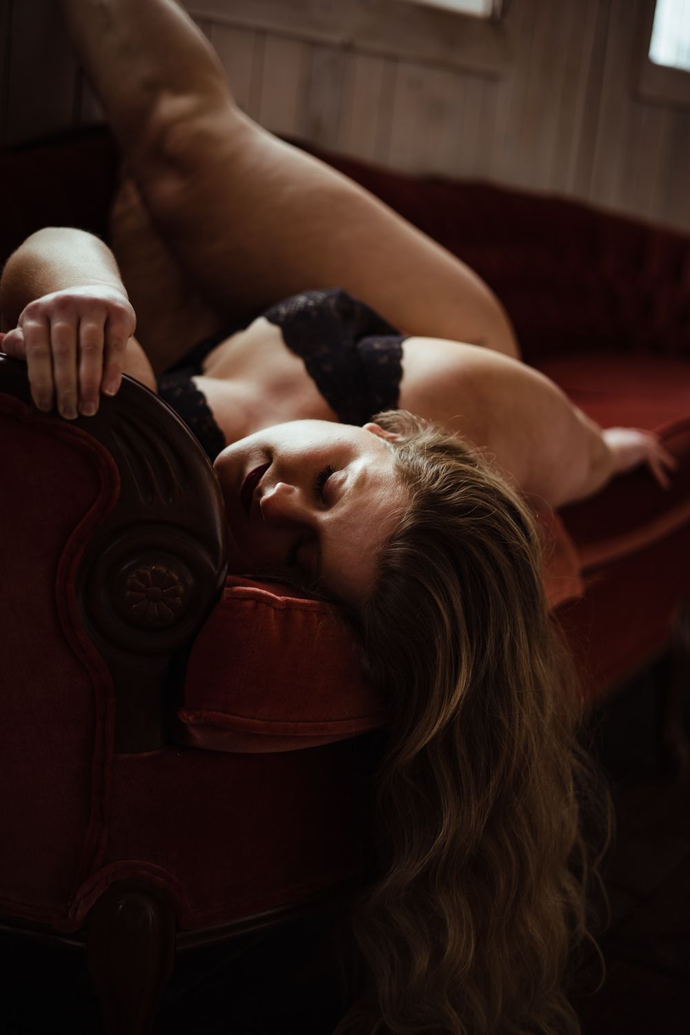 Artistic portrait with dramatic shadows and red tones.