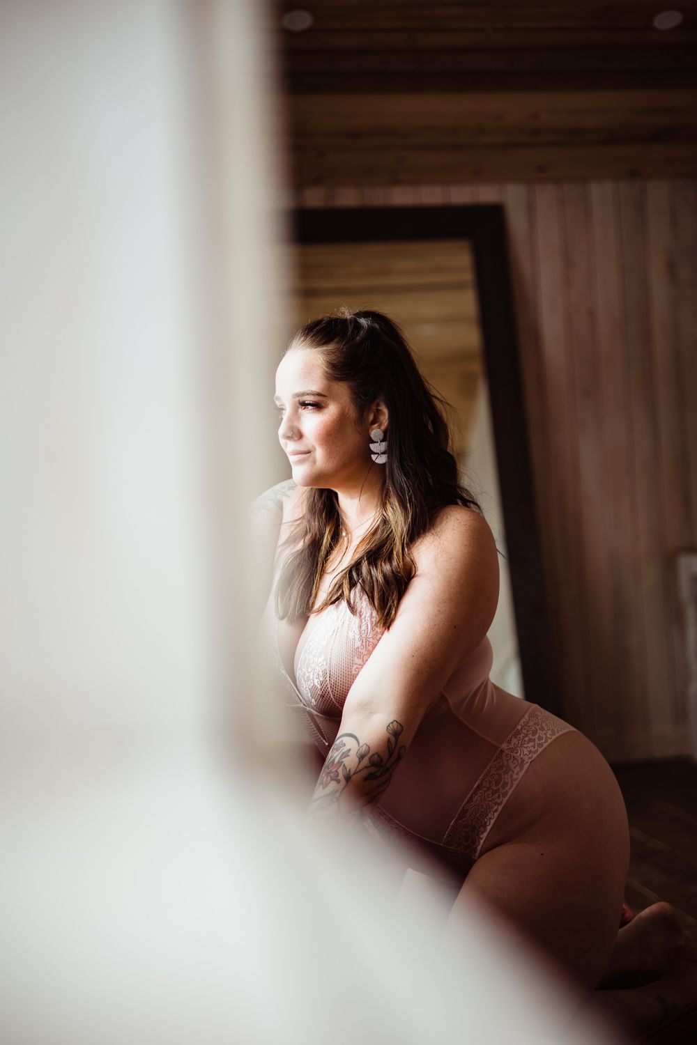 Soft focus boudoir photography with natural window lighting.