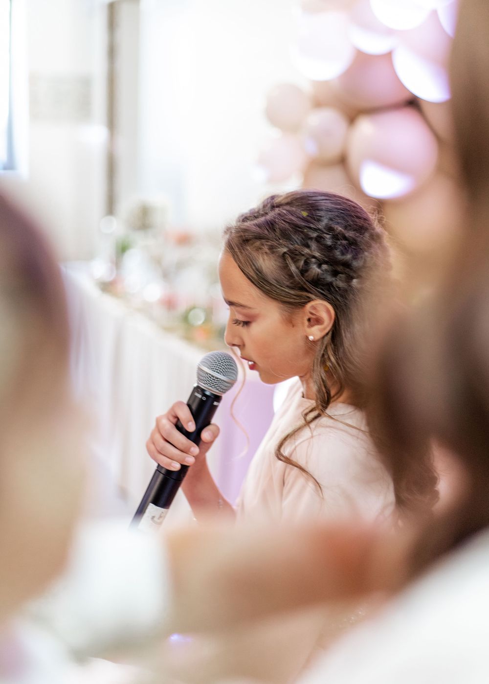 Elegant braided hairstyle detail with microphone in soft romantic lighting.