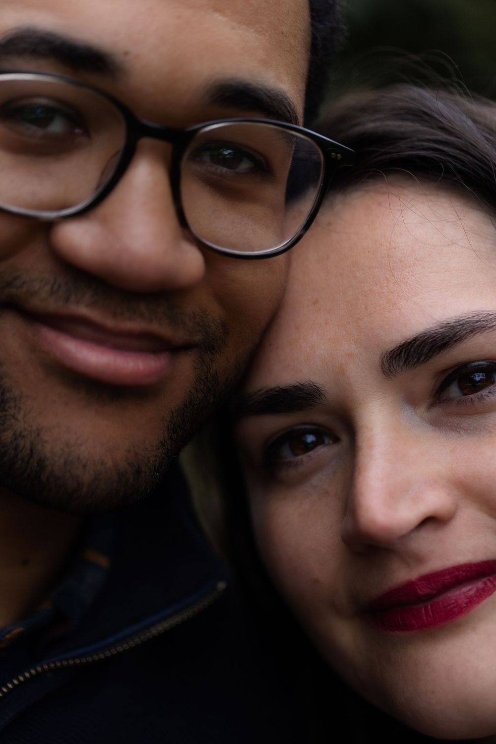 A close-up intimate portrait of a couple against natural background.