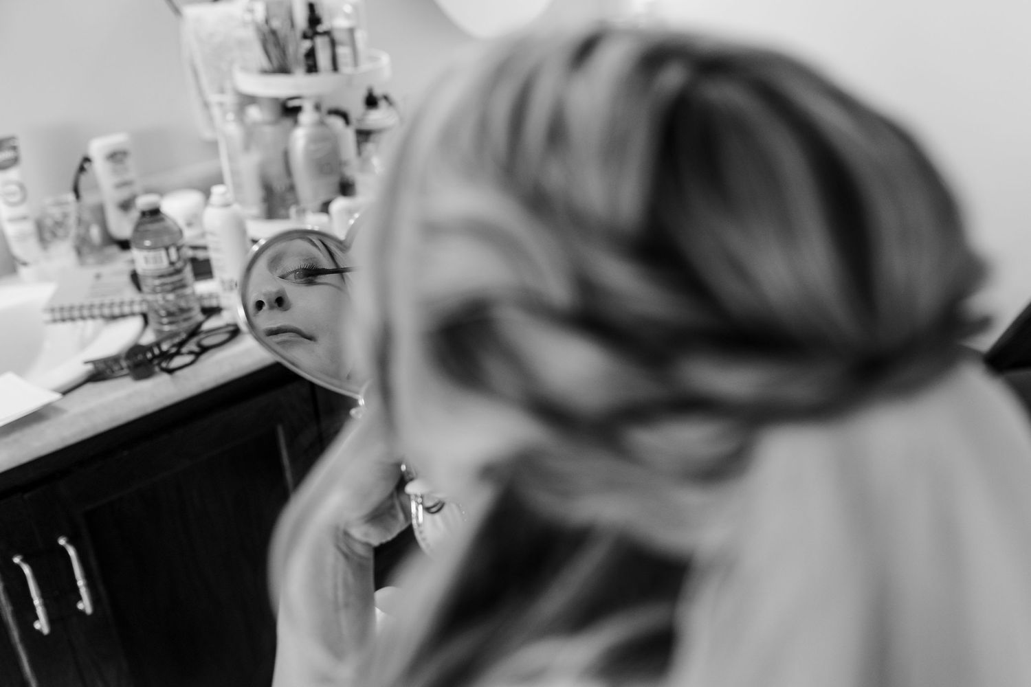 A series of emotional black and white photographs showing wedding day preparations in a bright room.