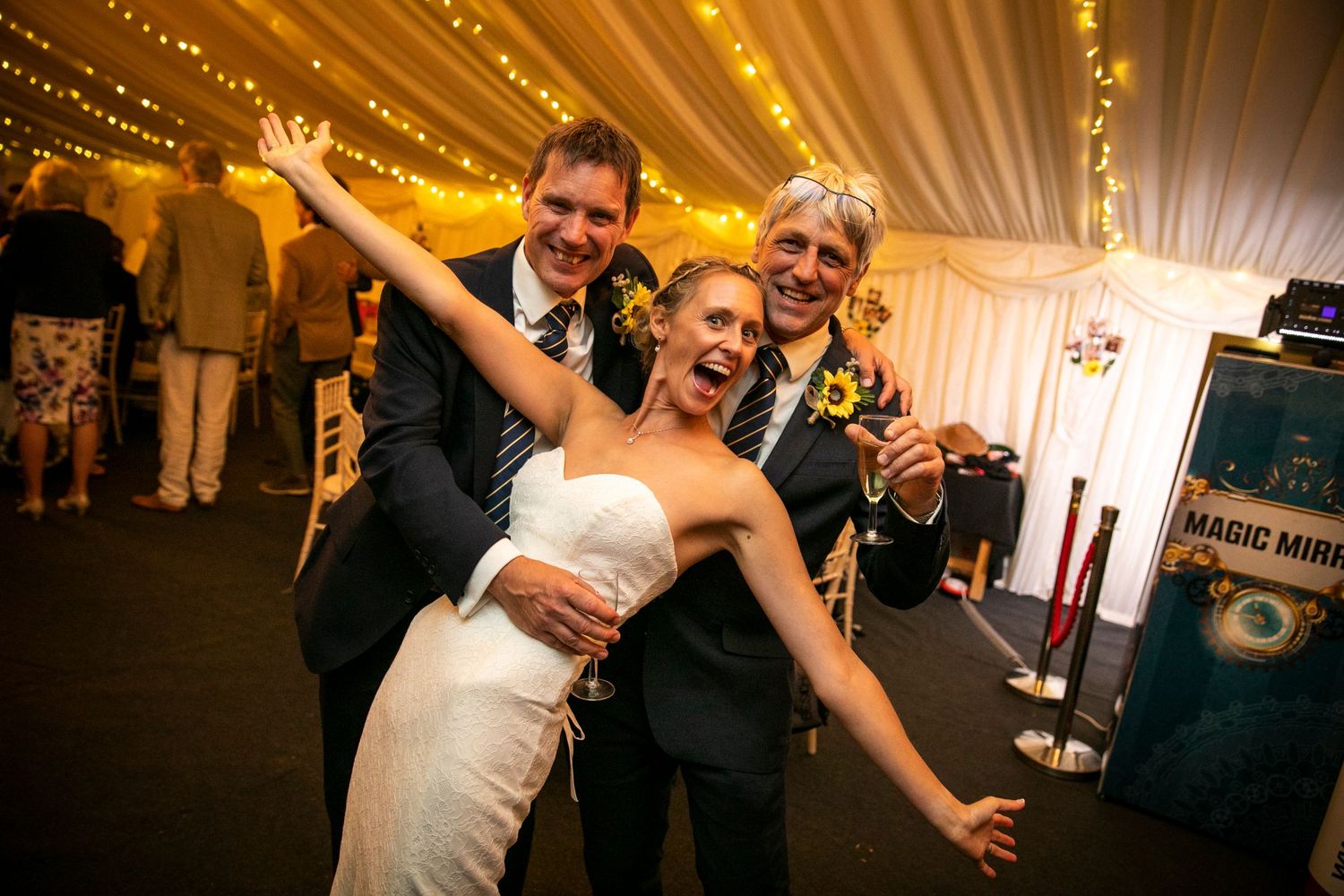Wedding reception dance floor filled with celebrating guests under warm string lights.