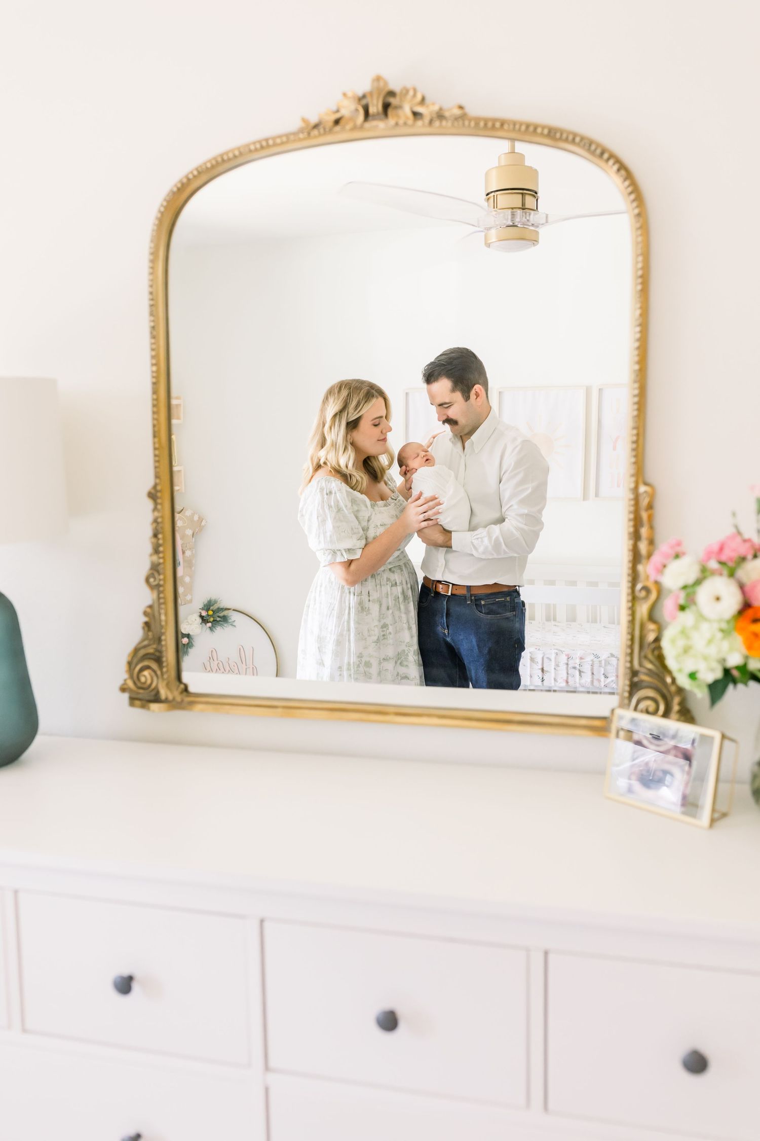 Elegant vintage mirror reflection showing nursery scene with baby.