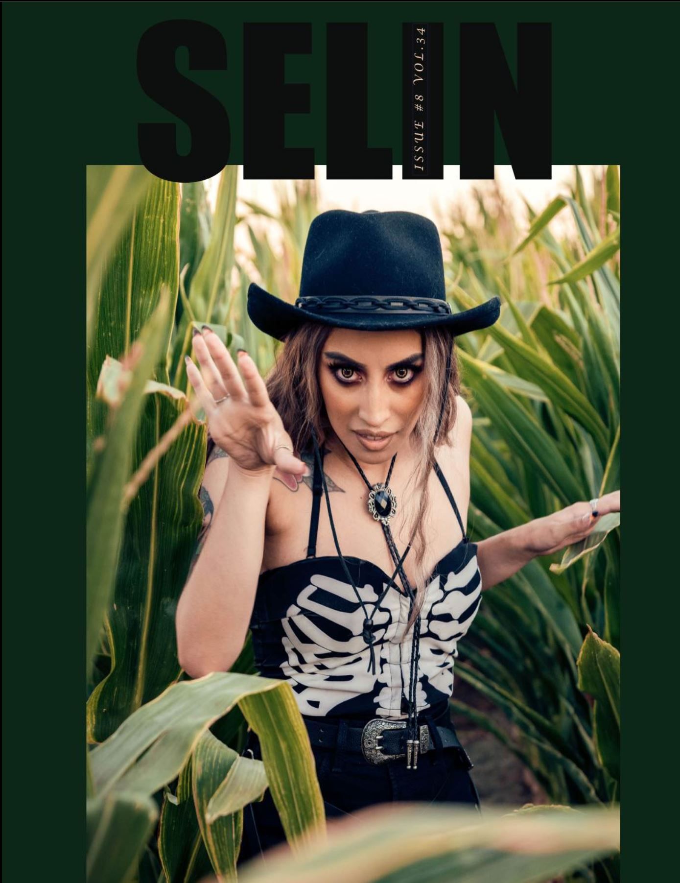 Model in skeleton corset and cowboy hat poses in cornfield for edgy fashion magazine cover. Captured by Chris Cornish Photography.