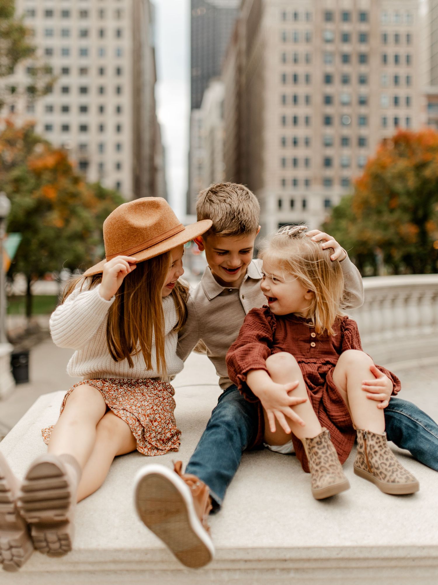 Family sharing laughs while sitting together in urban setting during autumn.