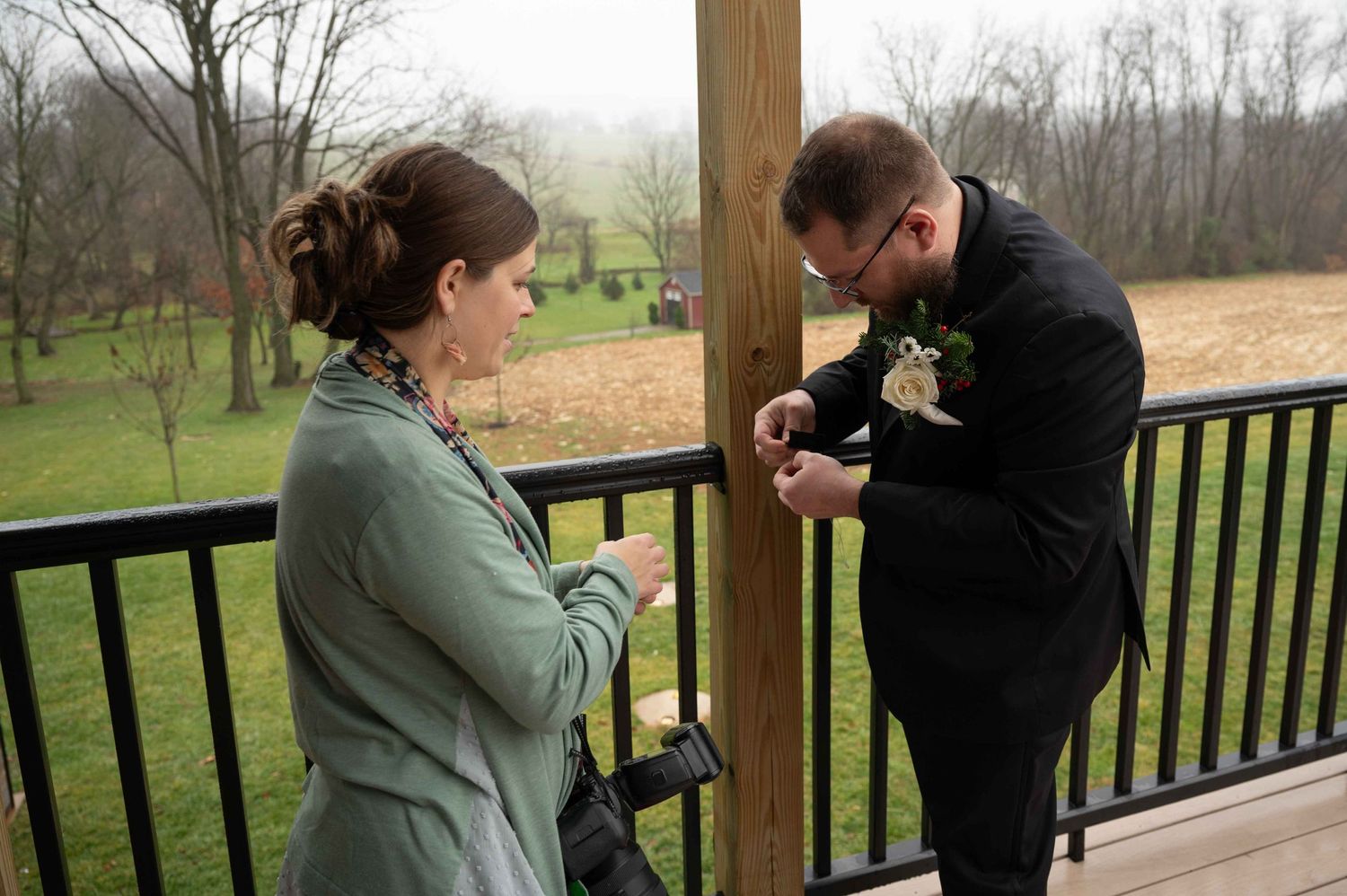 Two people on wooden deck having conversation during overcast day.