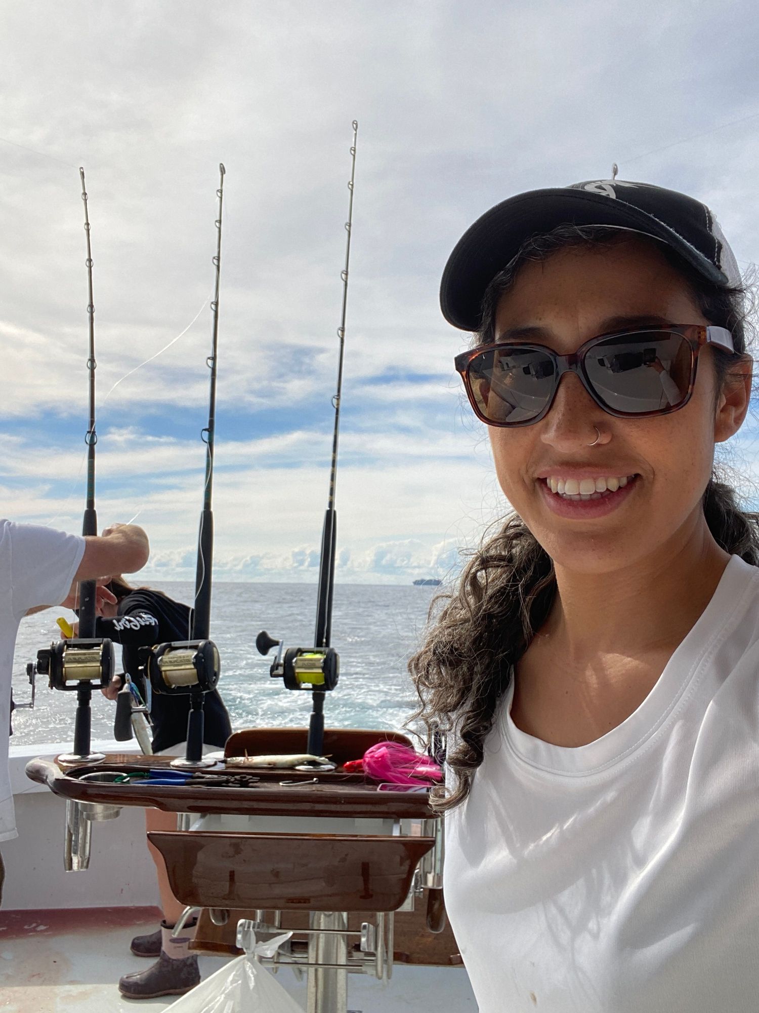 Fishing rods mounted on boat deck against ocean horizon.