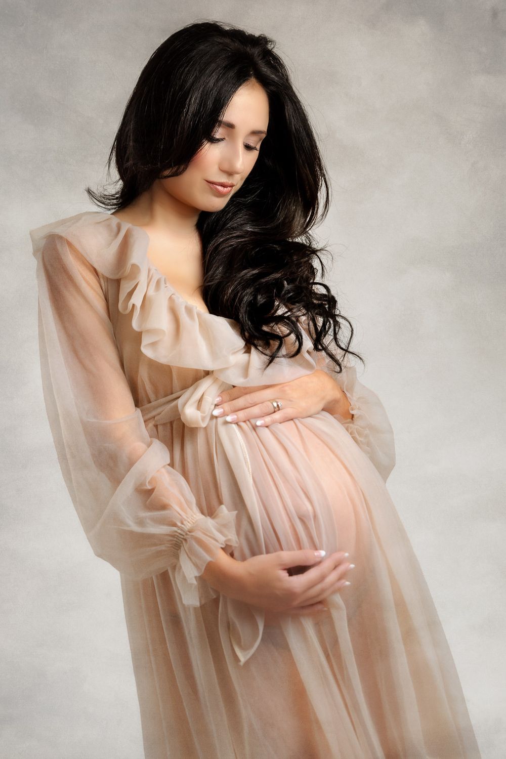 A series of four ethereal portraits showing a woman in a flowing sheer peach dress against a misty gray background.