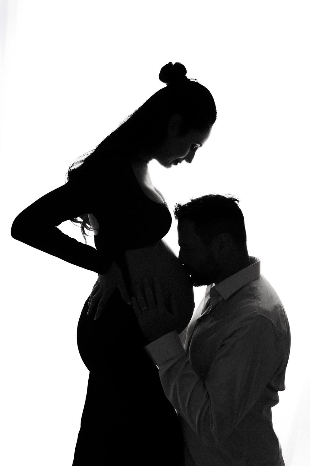 Black and white silhouettes show intimate dance poses between couples in a dramatic artistic composition.